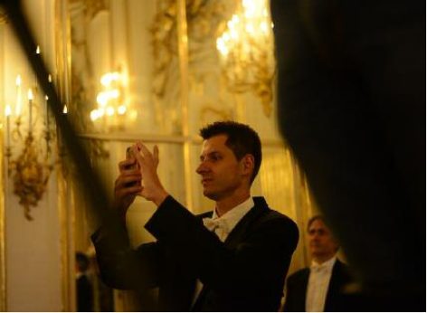 Un espectador del concierto del Palacio de Schönbrunn fotografía con su móvil para guardar un recuerdo de la noche maravillosa