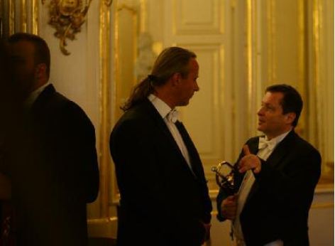 2 musicians of the Schoenbrunn Palace Orchestra before the performance. They are discussing the last details of the classical concert.